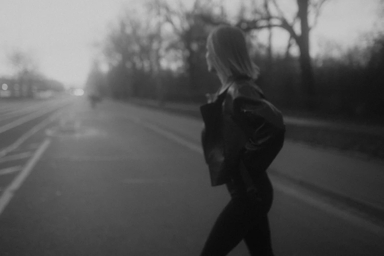 the black and white po of a woman crossing the street