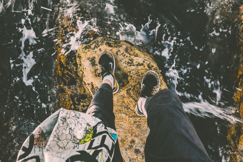 someone walking on the ground next to a body of water