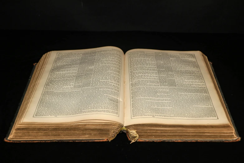 an open book sits on a black table