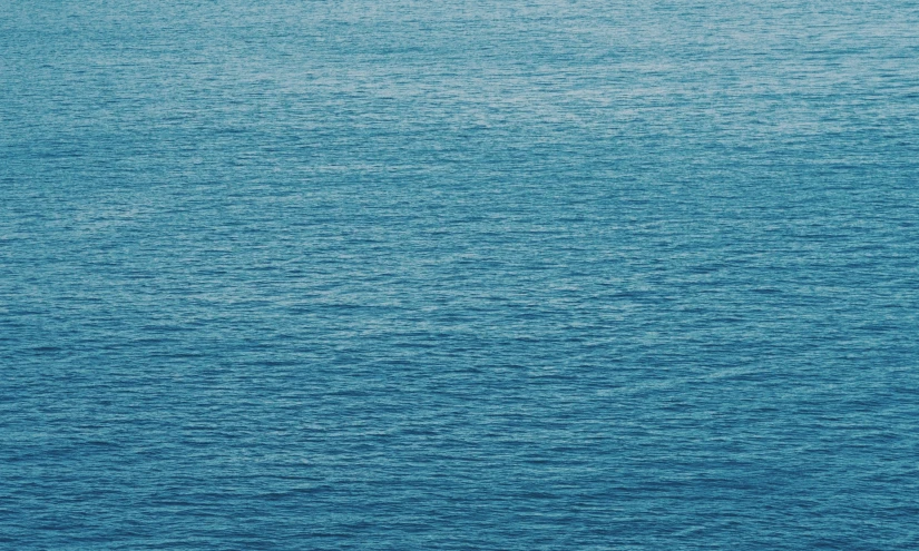 a lone boat floating on a large body of water