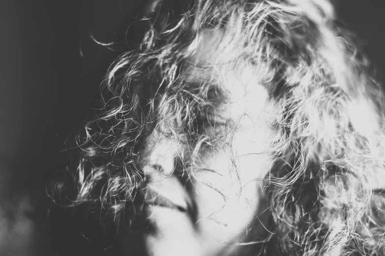 a girl's long curly hair and a on - down shirt