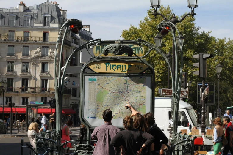 people at a street corner looking at the city map