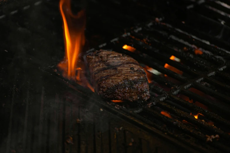 steak is grilling on a grill, in flames