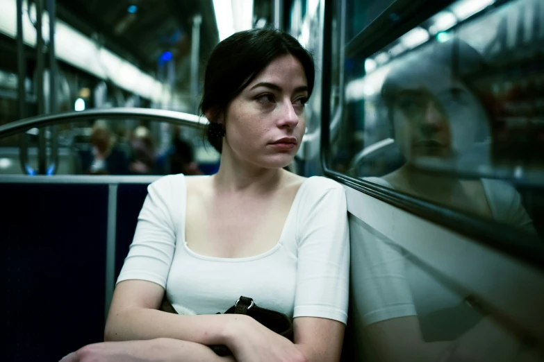 a woman is sitting on a subway car