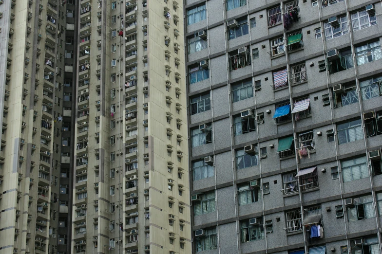 tall apartment buildings with windows, balconies and various signs on them