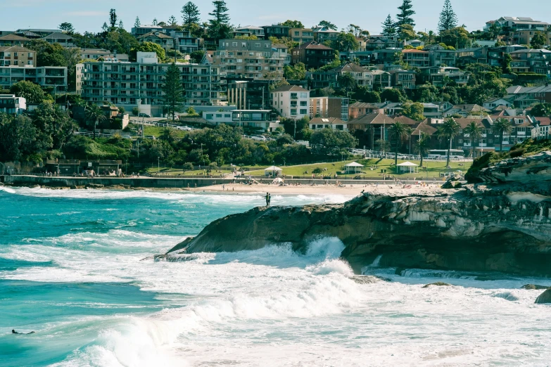 waves crashing on the beach near a city