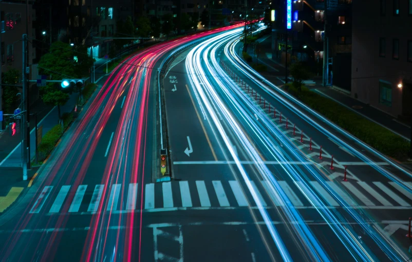 city highway lights streak across an intersection at night