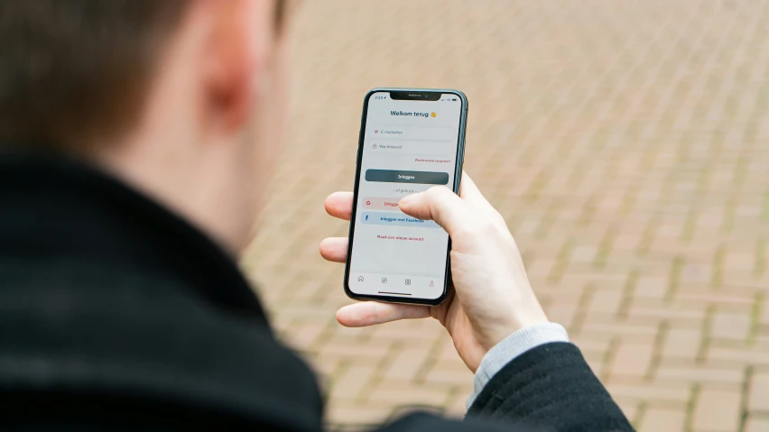 a person holding an iphone to show them what it is doing