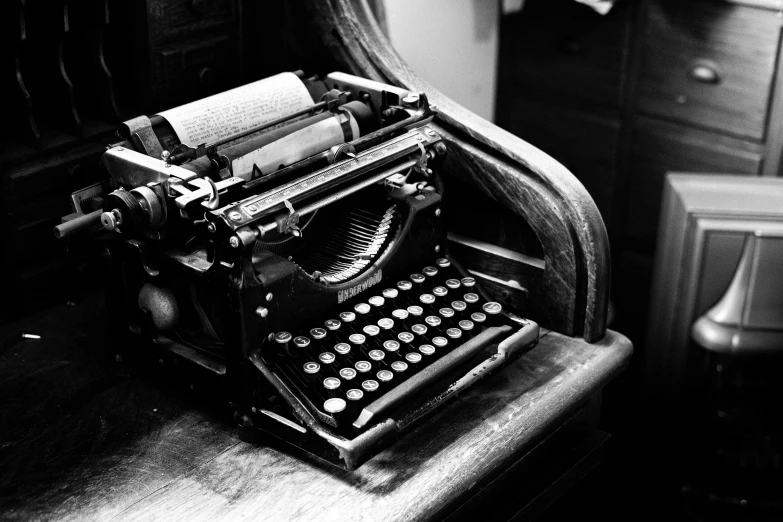 an old typewriter sits on an antique desk