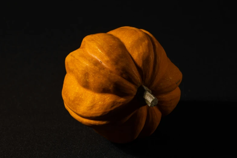 an orange pumpkin on a black background is pographed