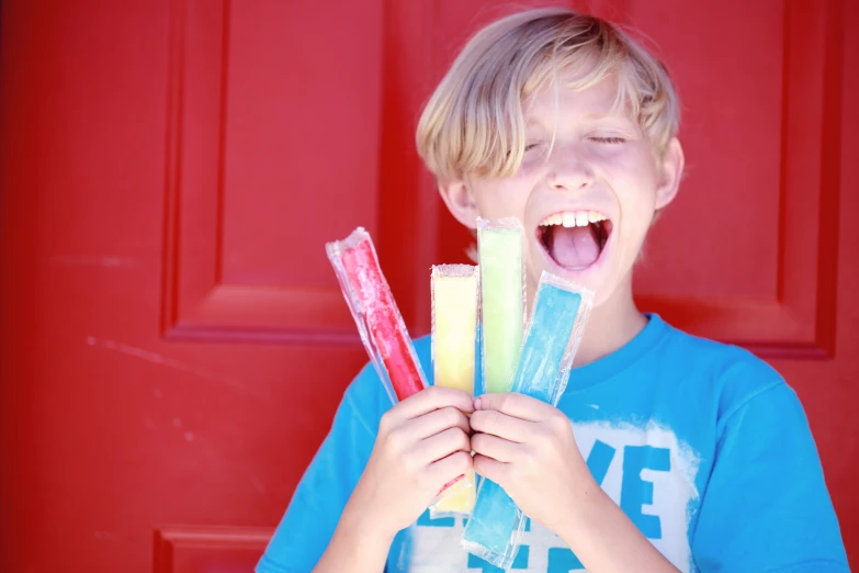 a boy opening his mouth with candy sticks