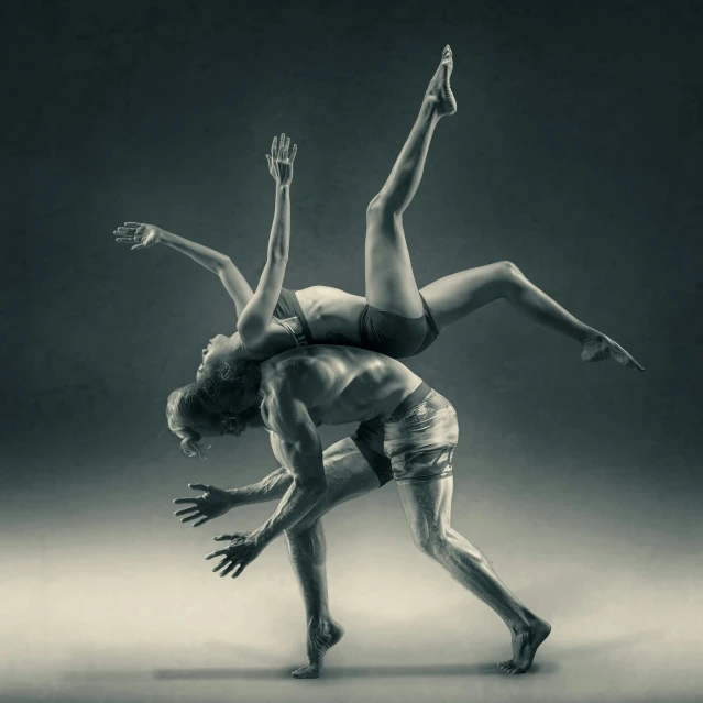 two men perform acrobatic tricks in the studio