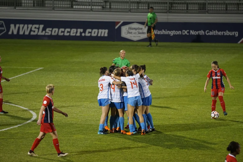 the women's soccer team is huddled up on the field