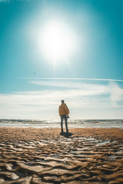 a man on a beach is standing in the sun