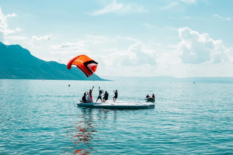 people out in the water para sailing on a sail