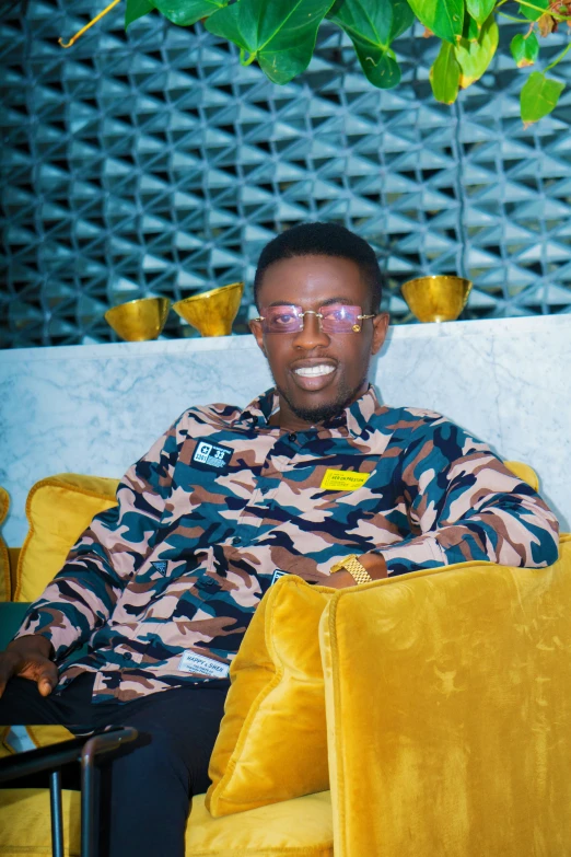 a man is sitting in a yellow chair and smiling