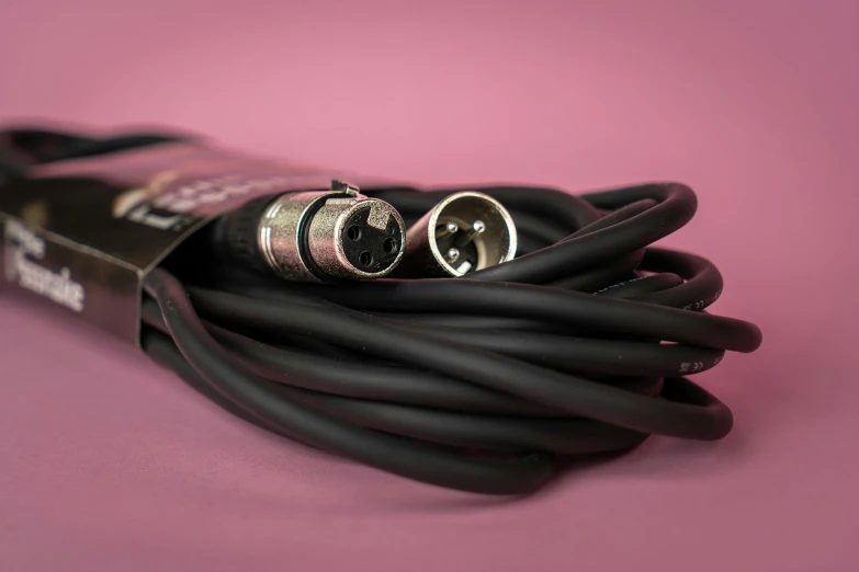 several pieces of leather cord and a pair of rings on a pink background