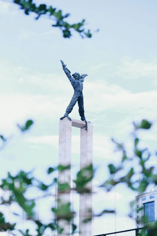 the sculpture is of a person standing on two columns