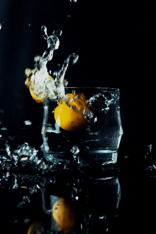 a glass of water with lemons and an orange on it