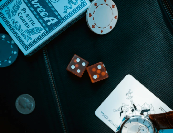 a gambling table with dice, playing cards and a watch