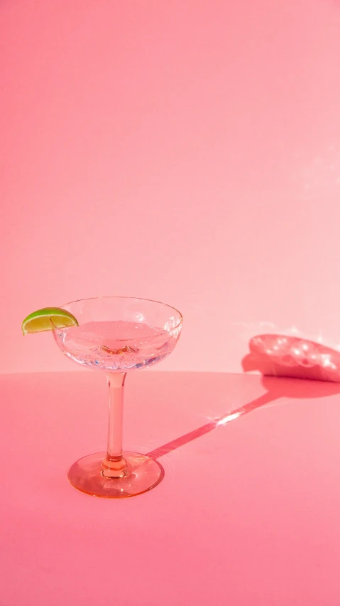 the margarita is on the pink counter next to a slice