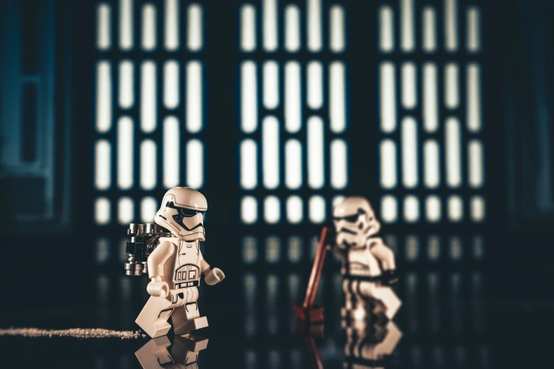 two lego figurines sitting on top of a desk