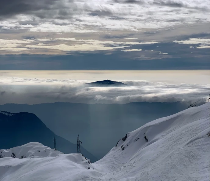 a view of the mountain with clouds below