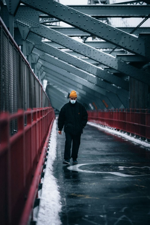 man walking through an overpass during a rain storm