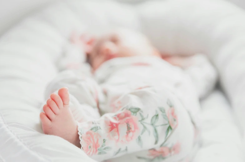 a small baby in a white wrap lying down