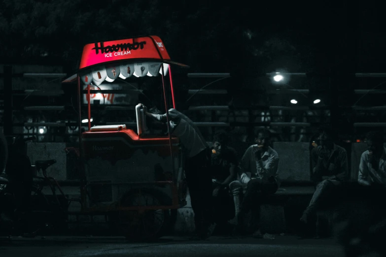 a red double decker bus traveling down a street at night