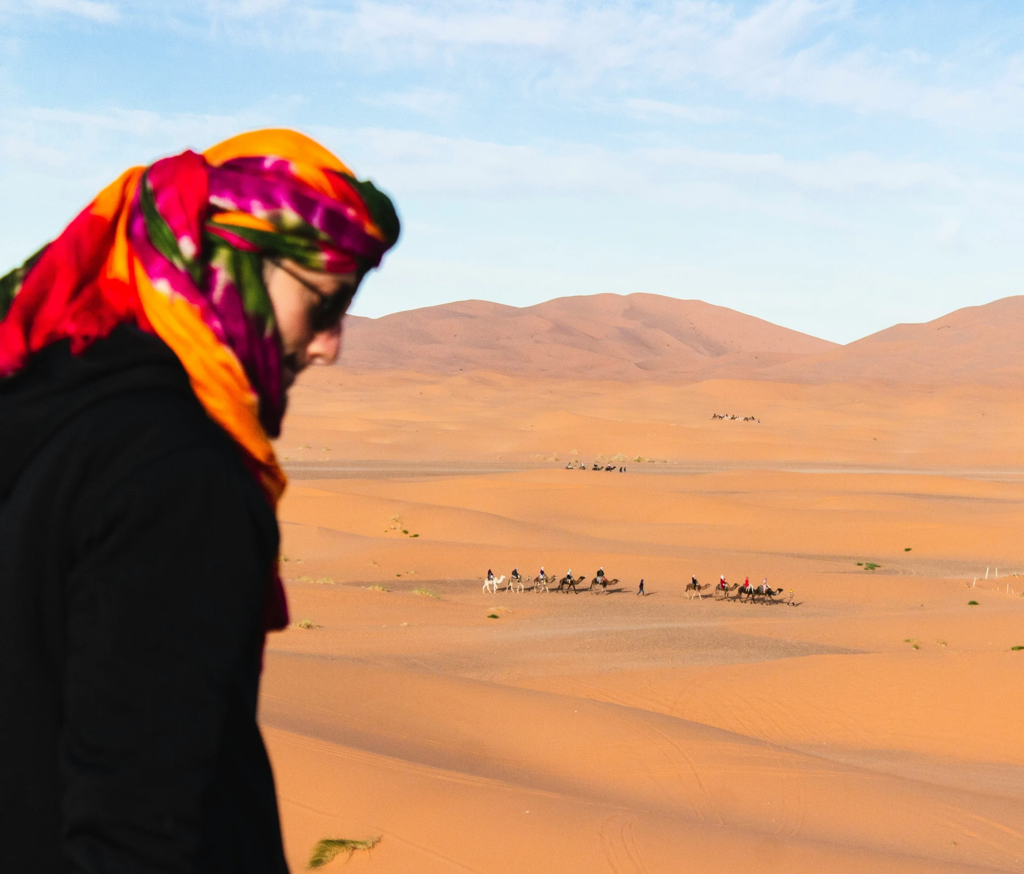 a person wearing a scarf and standing in the desert