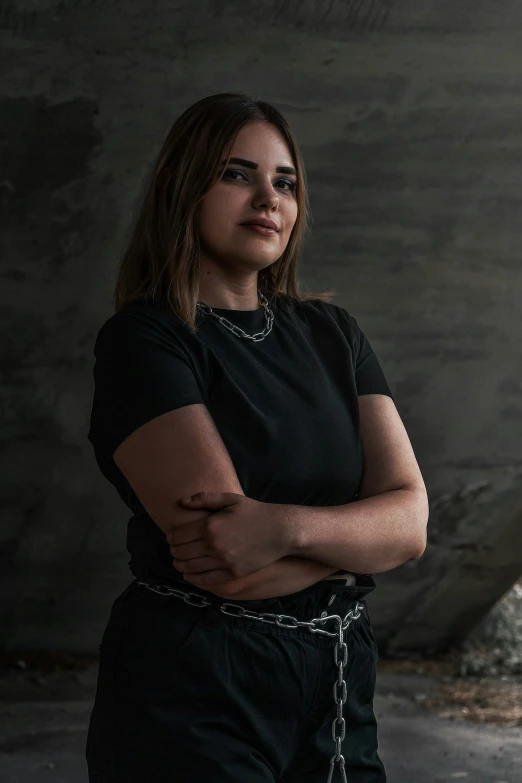 a girl wearing a black t - shirt with a chains and a watch