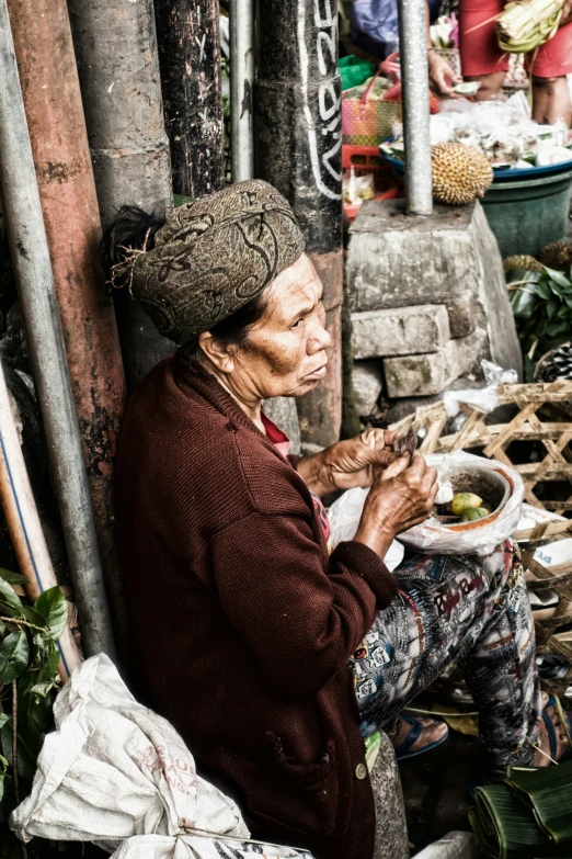 a woman sitting on a porch next to vegetables