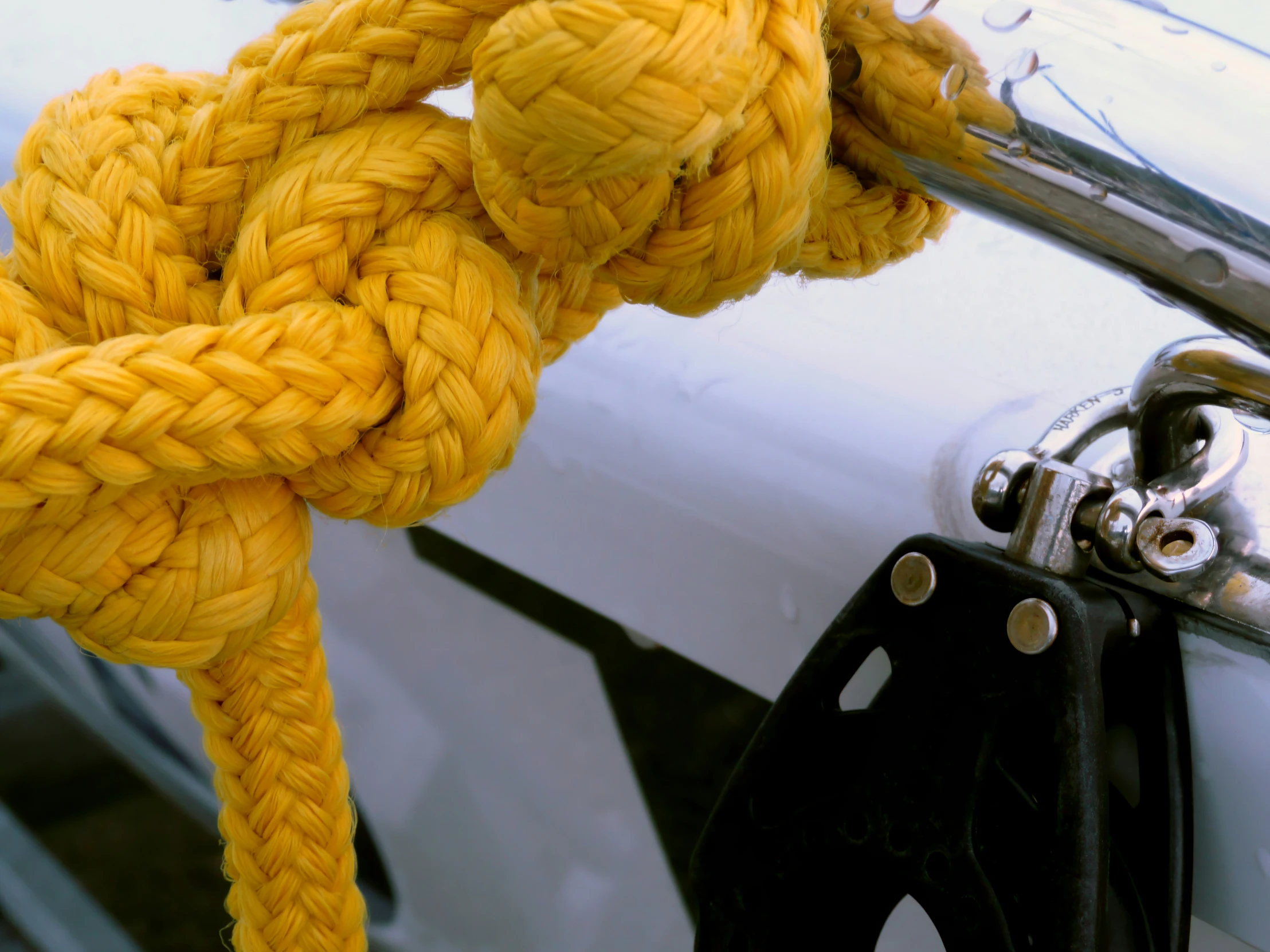 yellow ropes hang on a parked car in a parking lot