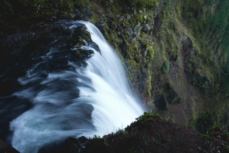 a waterfall is seen from above on the water