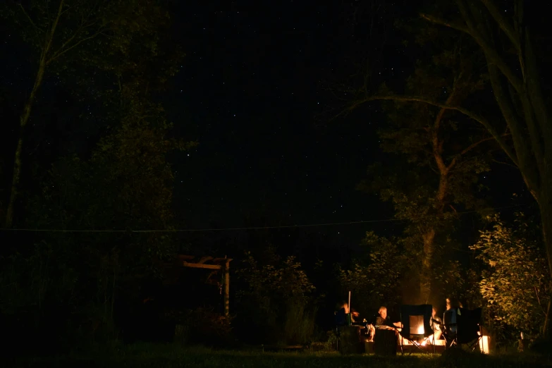 a fire pit at night with people sitting around it