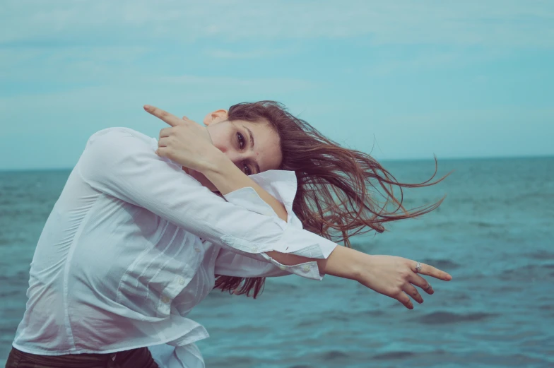 a woman is standing on the edge of a cliff