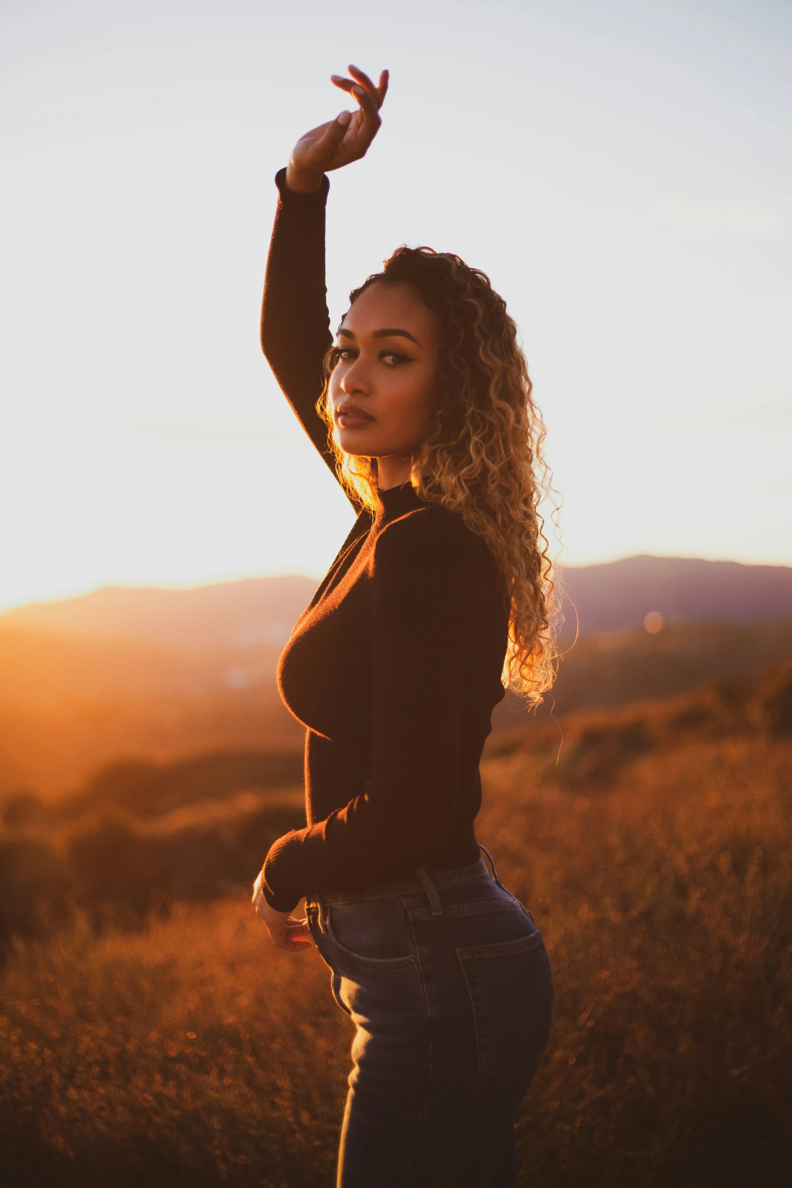 a woman is posing for a po in a grassy field