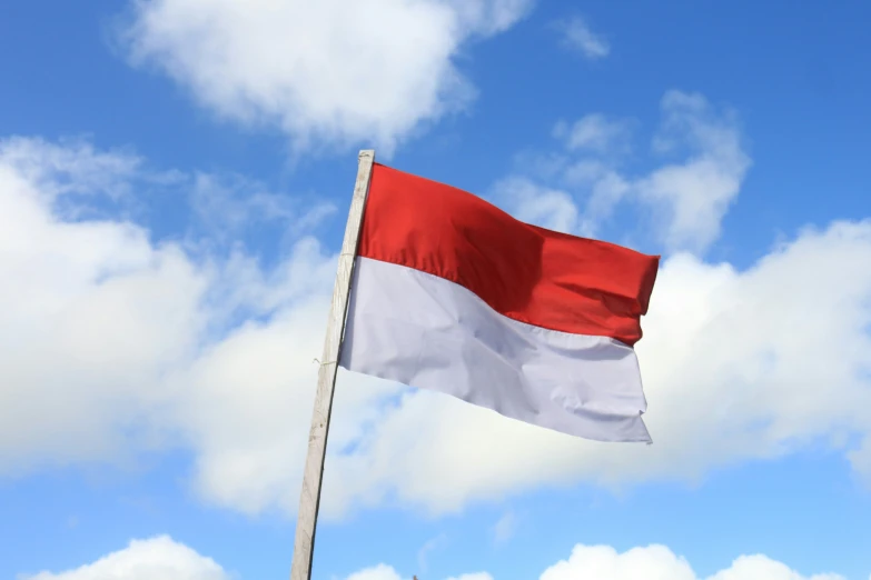 a large red and white flag flying in the air