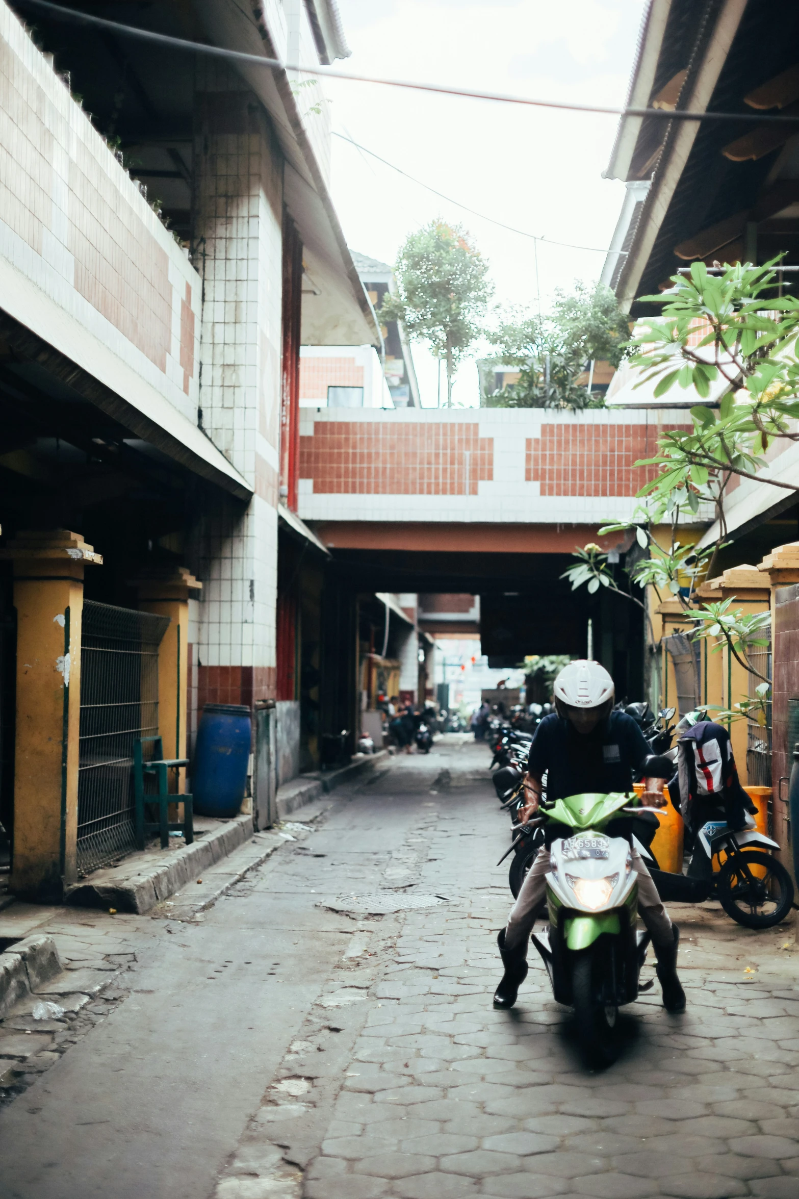 some motor scooters in the alley between two buildings