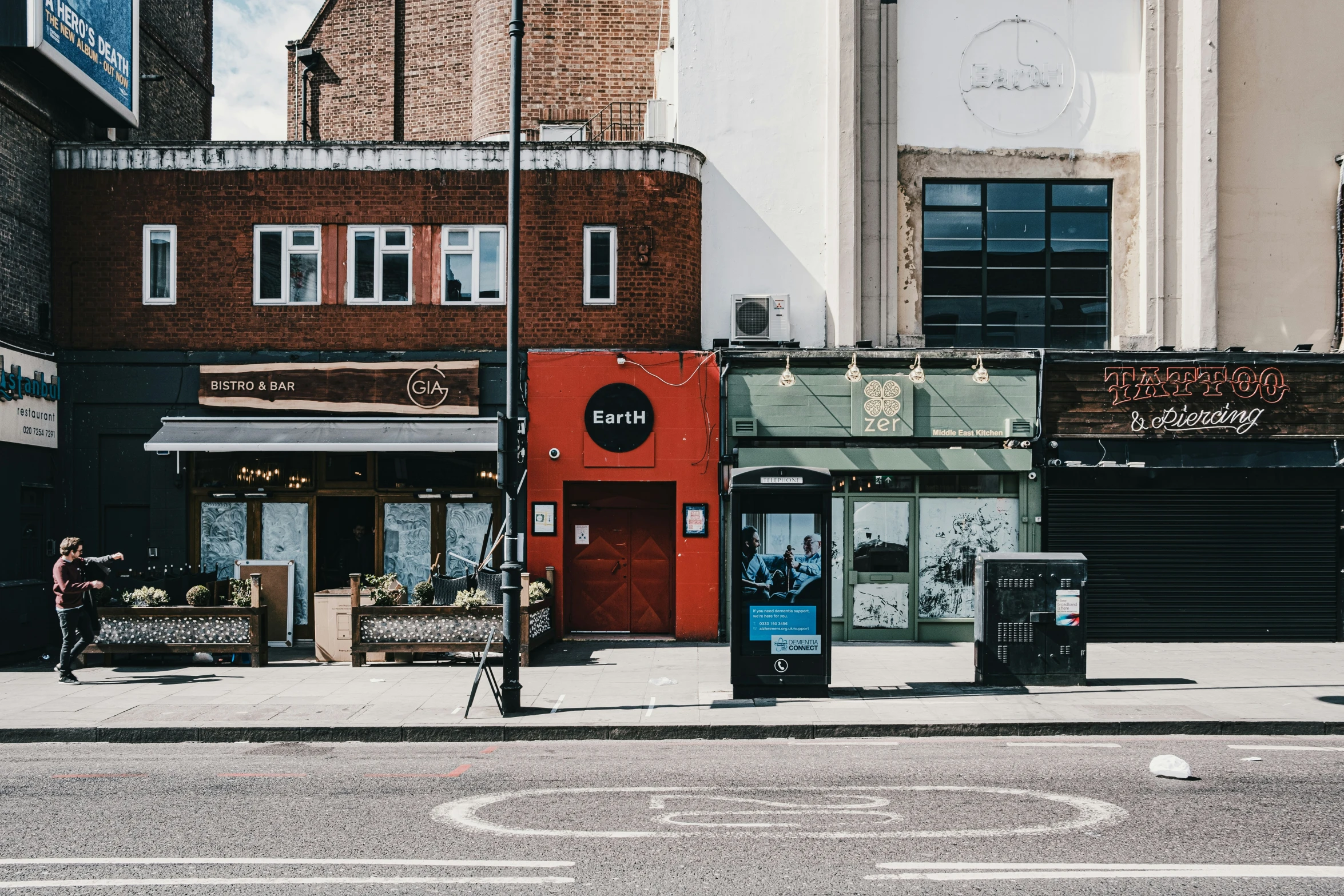 a man walks down the street by an empty sidewalk