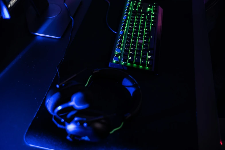 keyboard and mouse lit up on a black desk