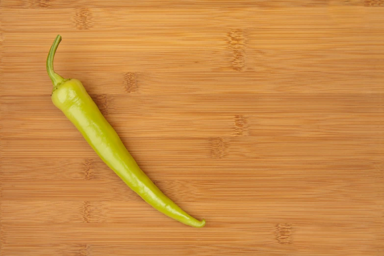 a green pepper sitting on top of a wooden table