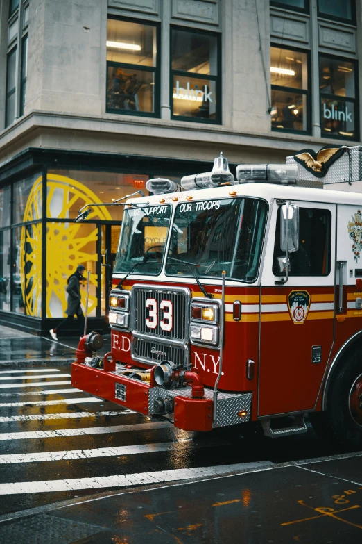 an fire engine sits in front of a building in the rain