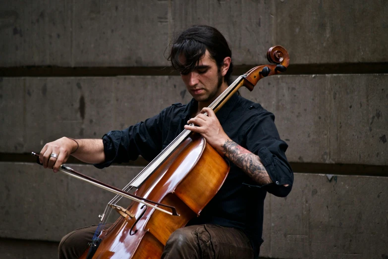 a man holding his cello while sitting down