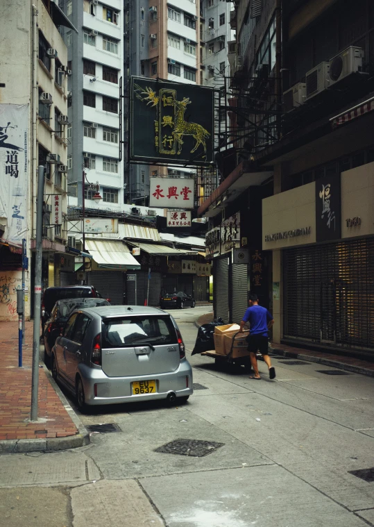 a man hing a luggage cart down an empty street