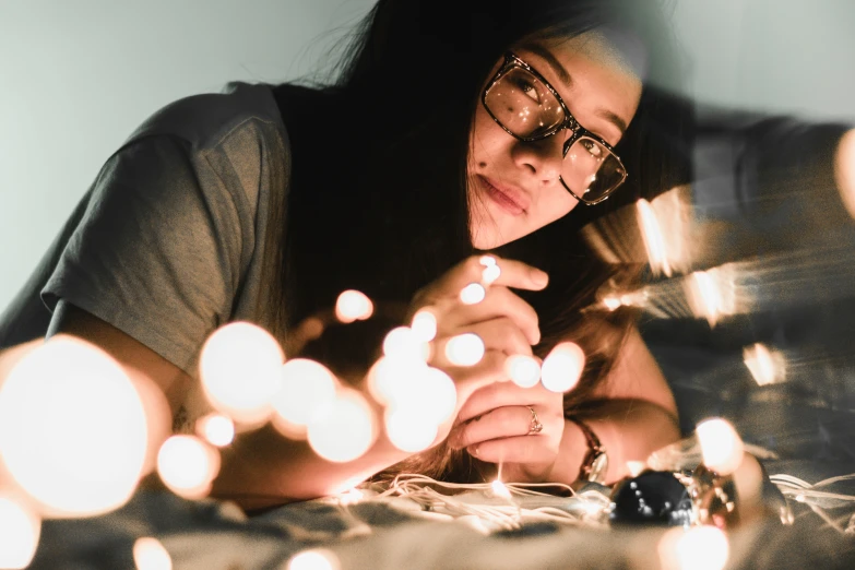 woman sitting down looking at the lights on a mirror