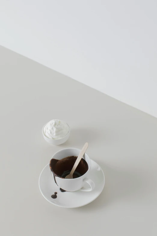 a white cup of coffee with a spoon in it