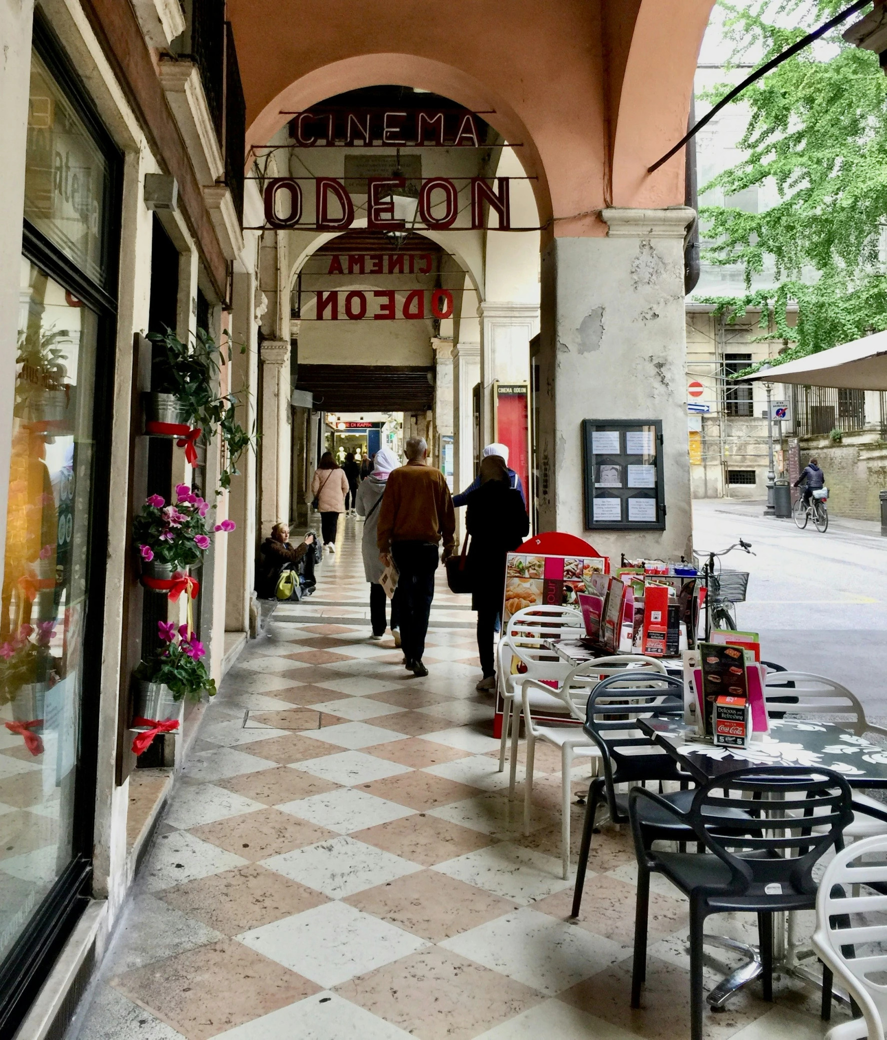 the street is filled with people walking down the sidewalk