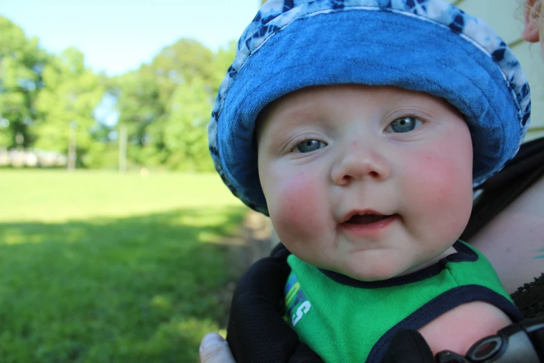 a close up of a baby wearing a blue hat